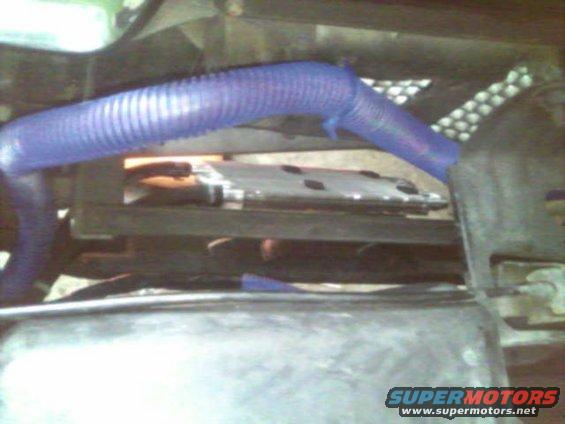 Close-up of a blue corrugated hose in an engine bay