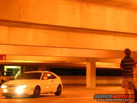 White 1990 Volkswagen Corrado parked in a garage with headlights on
