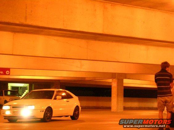 White 1990 Volkswagen Corrado parked in a garage with headlights on