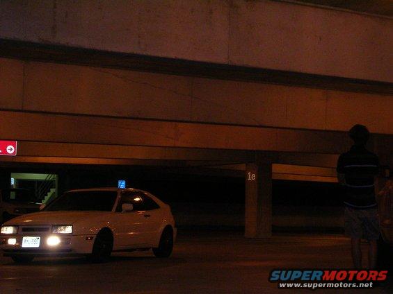 White 1990 Volkswagen Corrado with a blue light on the roof, parked in a dimly lit garage