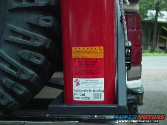 Spare tire and red fuel can mounted on the rear of a vehicle