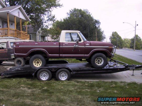Maroon and white pickup truck on trailer, side view. Appears to be 1970s Ford F-Series