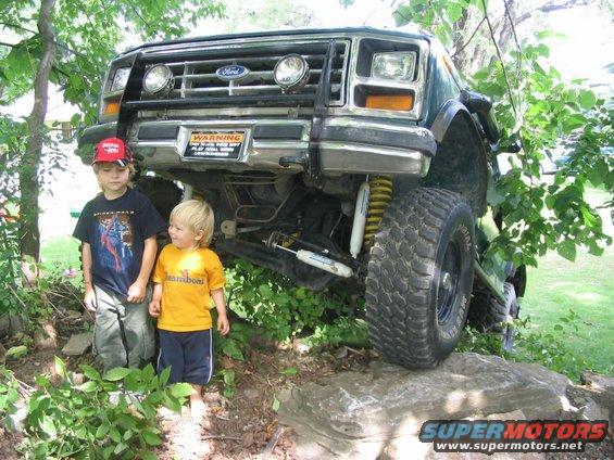 1986 Ford Bronco on rocks with two kids standing in front