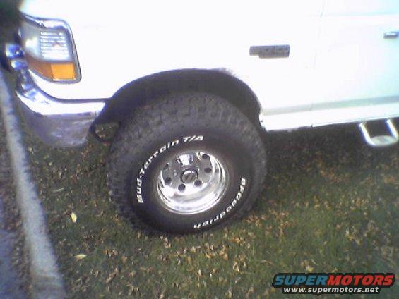 Close-up of a white Ford Bronco's front wheel and fender. BFGoodrich Mud-Terrain T/A tires are visible