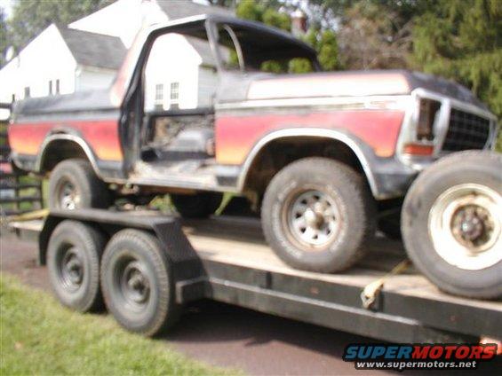 Ford Bronco on a trailer, doors removed, red and black paint