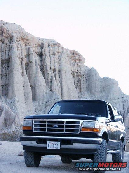 Black Ford Bronco parked in front of rock formations. License plate reads 'T-DOG'