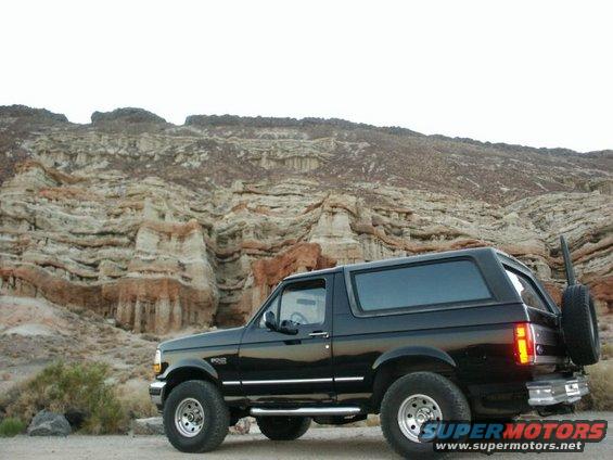Black 1996 Ford Bronco parked in a desert landscape with rock formations
