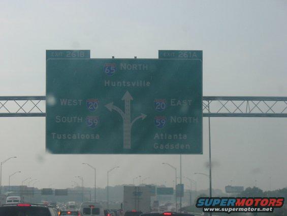 Highway exit sign showing directions for I-65 North to Huntsville, I-20 West to Tuscaloosa, and I-59 South to Tuscaloosa