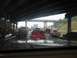 1988 Ford Bronco - A view from inside a vehicle shows a traffic jam on a wet highway under an overpass with multiple cars and trucks.