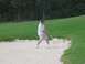 1988 Ford Bronco - A golfer attempts a shot from a sand trap on a golf course.