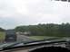 1988 Ford Bronco - View from inside a vehicle driving on a highway with multiple vehicles ahead on a cloudy day.