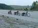 1995 Mercury Grand Marquis - Three motorcycles are parked on the side of a highway, with helmets laid out on the ground beside them.