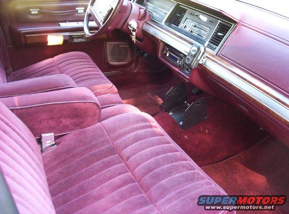 Maroon velour interior of a 1991 Ford Crown Victoria LTD, showing front seats, dashboard, and steering wheel