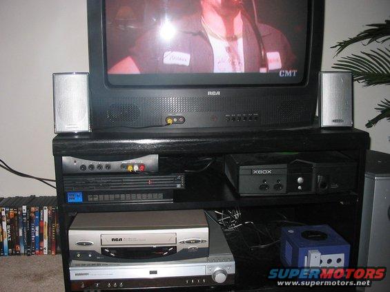 Television on a black entertainment stand with VCR, DVD player, Xbox, and GameCube