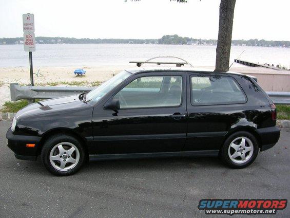 1996 Volkswagen GTI parked by a beach with a tree growing through its roof