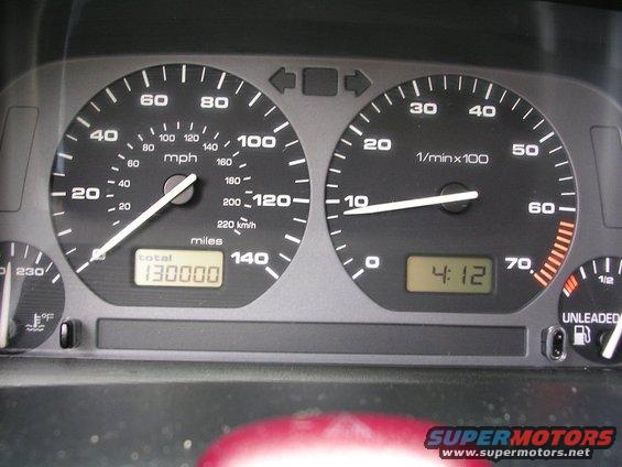 Car dashboard with speedometer, tachometer, and digital clock showing 4:12. Odometer reads 130000 miles