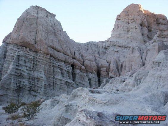 Rock formations in a desert landscape with a "SUPERMOTORS" watermark