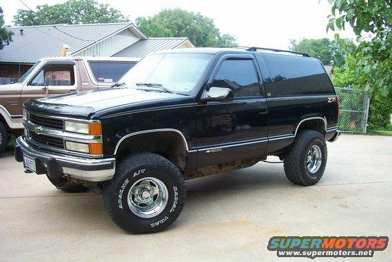 Black Chevrolet Tahoe parked next to a brown Ford Bronco