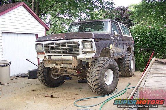 1978 Ford Bronco modified with a lift kit and oversized off-road tires, parked in a driveway