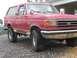 1989 Ford Bronco - Front 3/4 view of a red 1989 Ford Bronco with tan side trim.
