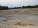 1989 Ford Bronco - A wide view of a quarry with layered dirt and rock formations under a dusky sky.