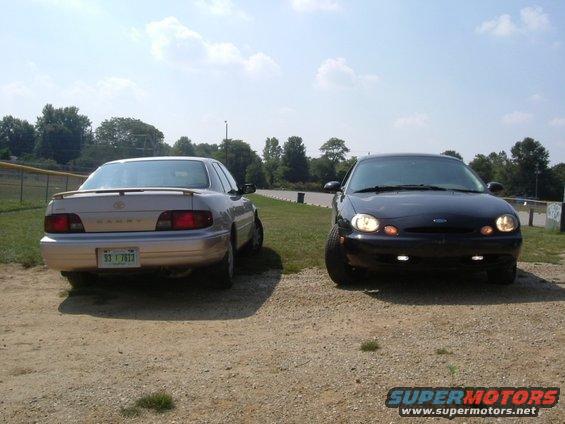 black Ford Taurus and tan Toyota Camry parked side-by-side