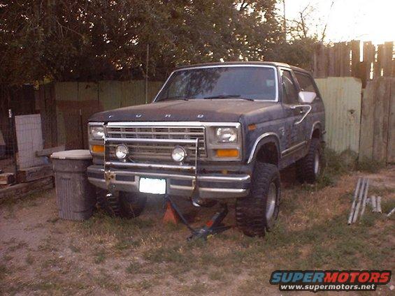 Dark blue Ford Bronco, front view, with brush guard and aftermarket lights