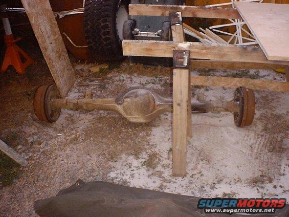 Rear axle assembly with drum brakes, supported by wooden beams