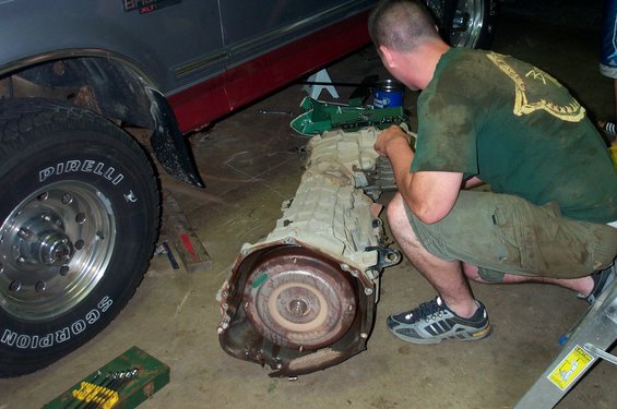 Transmission removed from a truck, with a man working on it