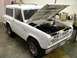 1967 Ford Bronco - A white 1966 Ford Bronco is parked indoors with its hood open, revealing the engine compartment.