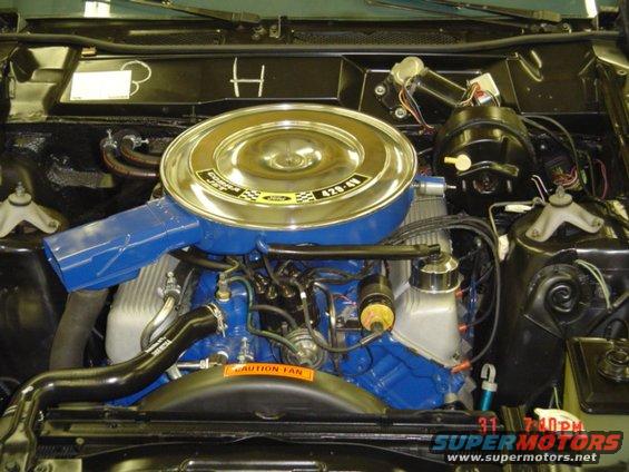 Engine bay with blue Ford 429-4V engine, chrome air cleaner, and "CAUTION - FAN" sticker