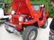 1967 Ford Bronco - A red Willys Jeep is parked next to a white Jeep, with the red Jeep's hood open.