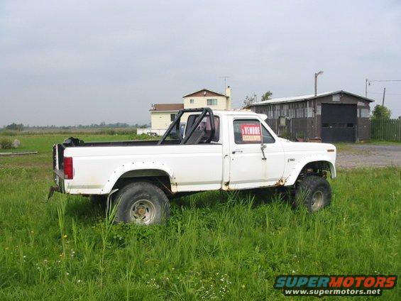 White pickup truck with roll bar and "A VENDRE" sign, side view