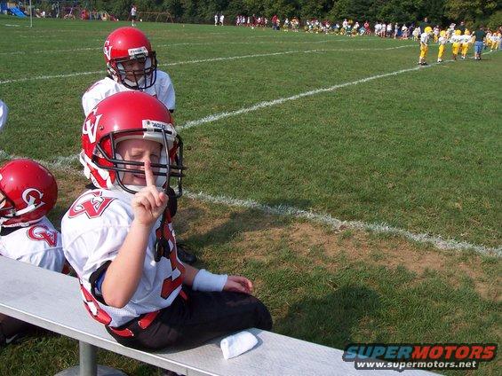 Football player on bench with finger to lips