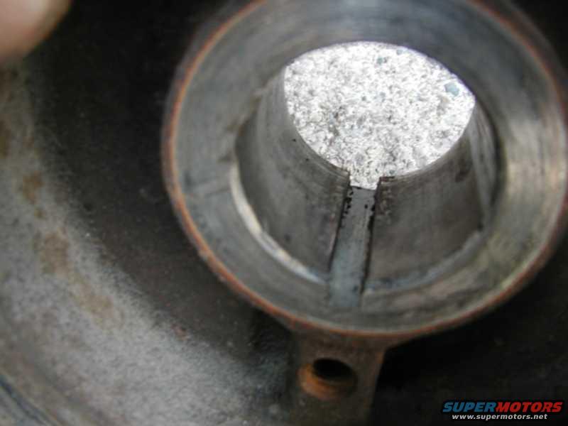 Close-up of a damaged metal pipe interior with debris