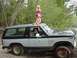 1982 Ford Bronco - A two-tone gray and black Ford Bronco is parked outdoors with two young girls sitting on its roof.