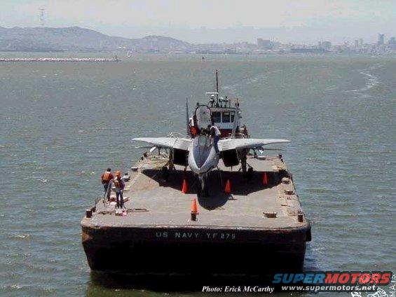 Barge with fighter jet on water, text 'US NAVY YF 279'
