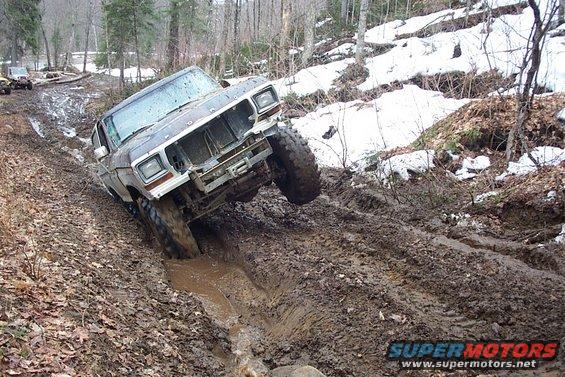 1978 Ford Bronco navigating a muddy trail with one wheel off the ground
