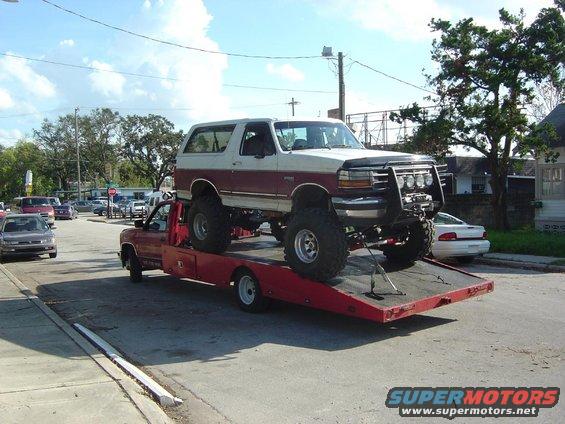 Lifted 1993 Ford Bronco on tow truck, two-tone paint, bull bar