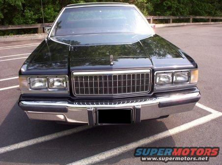 Front view of a black sedan with a chrome grille and rectangular headlights