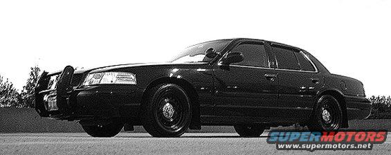 Black 2000 Ford Crown Victoria police car with a push bumper, seen from the front three-quarter angle
