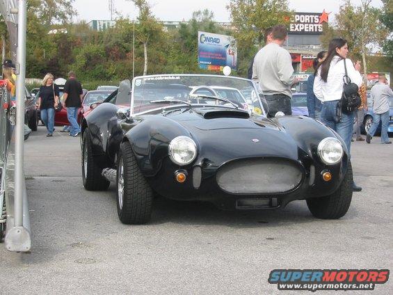 Black AC Cobra replica with a scoop on the hood and a mesh grille