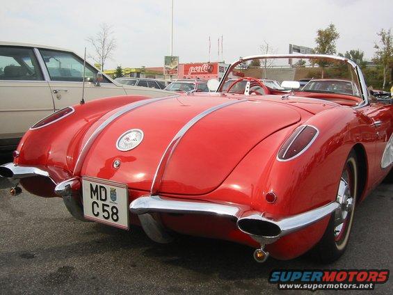 Red 1956 Chevrolet Corvette convertible rear view with chrome bumper and dual exhaust pipes