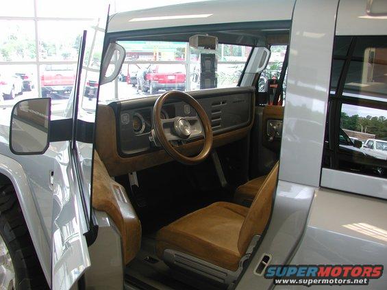 Interior view of a concept SUV, showing tan seats, a wood-rimmed steering wheel, and a dashboard with horizontal vents