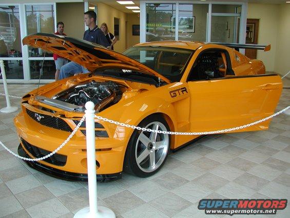 Orange custom sports car with hood open, GTR badging, and racing seat visible