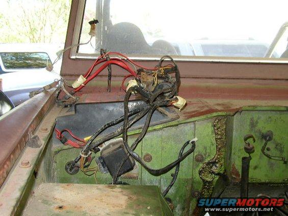 Close-up of a messy vehicle wiring harness in an engine bay
