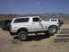 1988 Ford Bronco - White 1988 Ford Bronco navigates a set of concrete steps off-road.