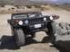1988 Ford Bronco - A black Hummer H1 navigates a rocky obstacle course in a dry, hilly landscape.
