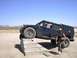 1988 Ford Bronco - A man stands next to a black Hummer H1 with its front tire on concrete steps.