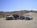 1988 Ford Bronco - Four-wheel drive vehicles gathered in a dusty, arid environment under a clear blue sky.